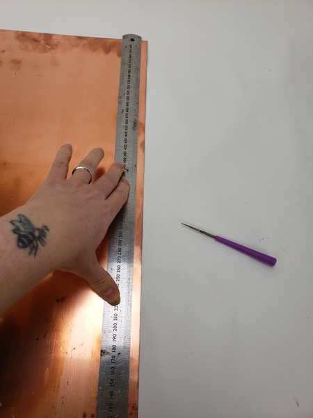 Place a sheet of copper on a flat surface