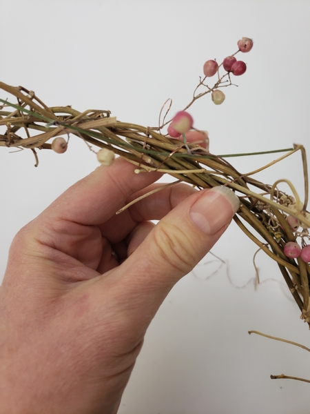 Place the dried berry stem on the wreath and wind the wire around both to secure