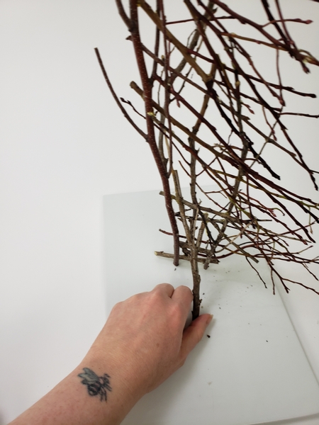 Add a twig to the back of the twig tree half so that it stands upright on a display surface