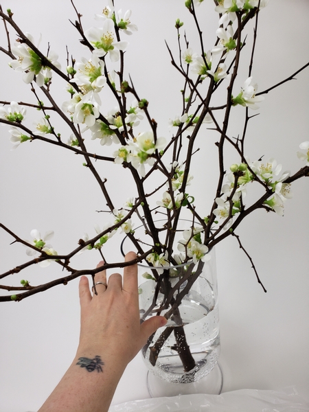 Place a generous bunch of blossom stems in a large glass vase