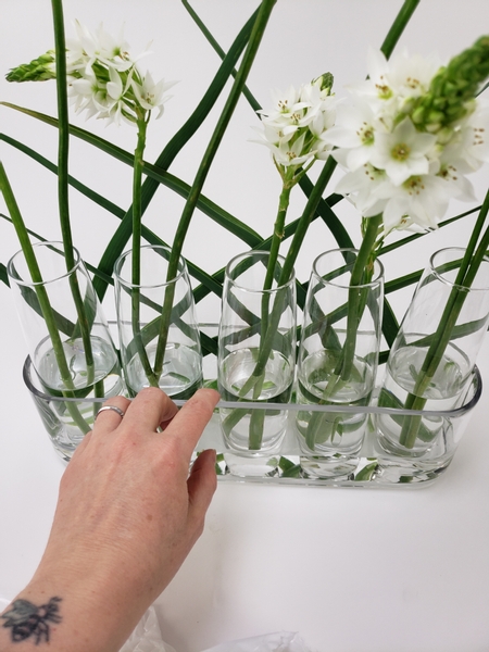 Turn the container and push the bud vases against the woven panel to make space for a second panel