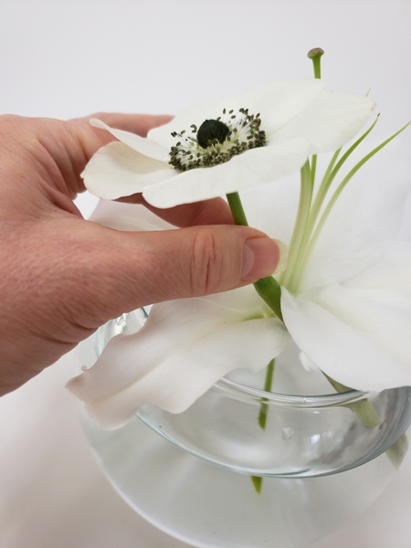 Carefully slip the anemone through the lily petals to keep it in place