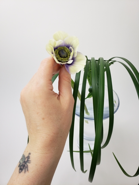 Slip the flower stem between the two tape strips in the front Slip the flower stem between the two tape strips in the front
