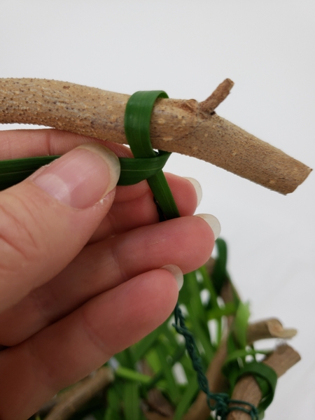 Loop a blade of grass around the wire to conceal it