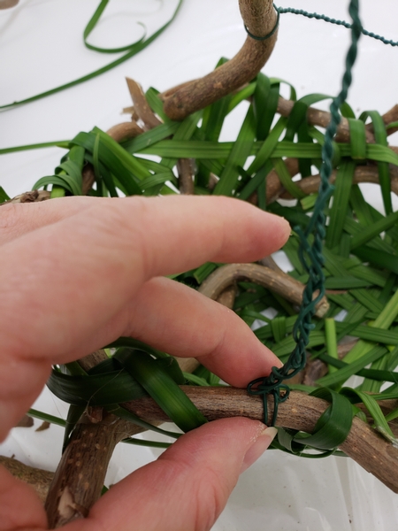 Secure the wire and twig handle to the basket frame