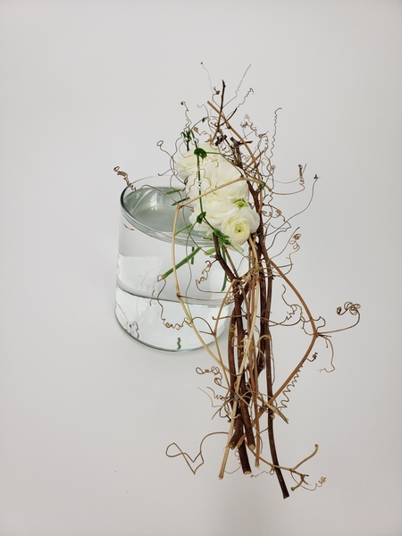 Craft a dried vine bridge to keep fresh flowers in place in a vase