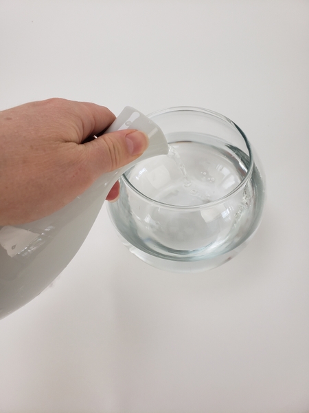 Fill a fishbowl vase with water Fill a fishbowl vase with water