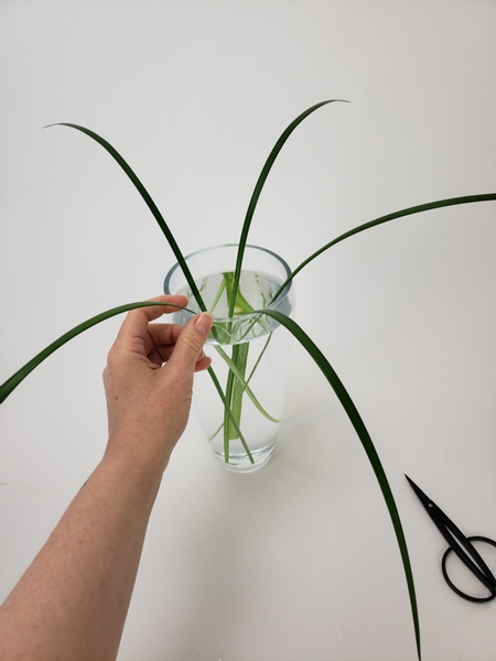 Add in more grass to radiate out of the vase