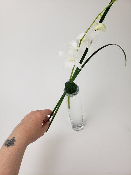 Creating an extension from the orchid stem all the way down to the other side of the bud vase