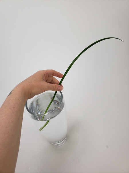 Slip a blade of grass into the tall vase to dangle over the side