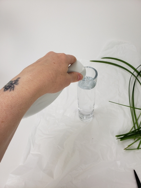 Fill a tall and narrow container with water