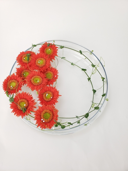 A hint at a wreath floral design in a water filled vase