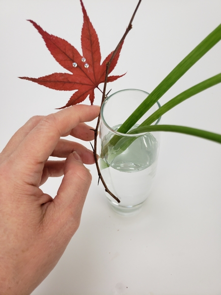 Glue the leaf to a thorn covered twig on the outside edge of the bud vase