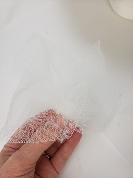 Cut a shorter strip of tulle and fold the end together to create a puff of tulle