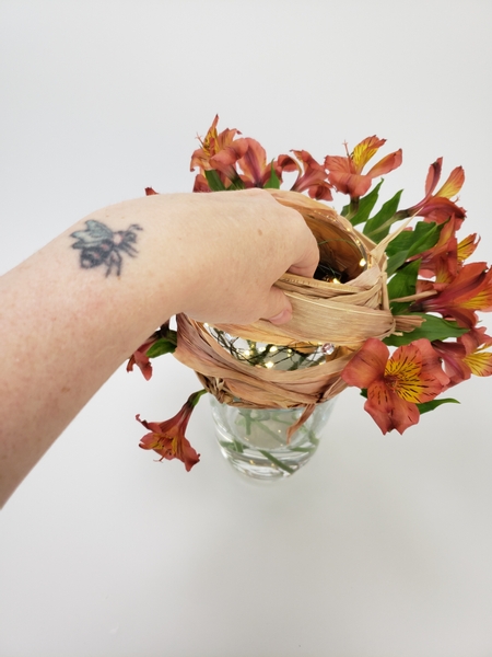 Place the fishbowl vase to rest on the flower stems