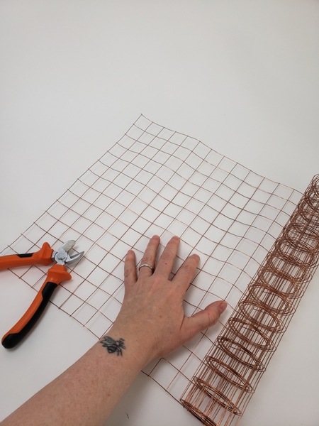 Roll out copper mesh on a flat working surface