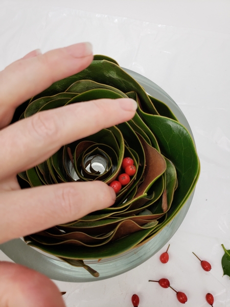 Cut a few holly berries and place it in the leaf roll
