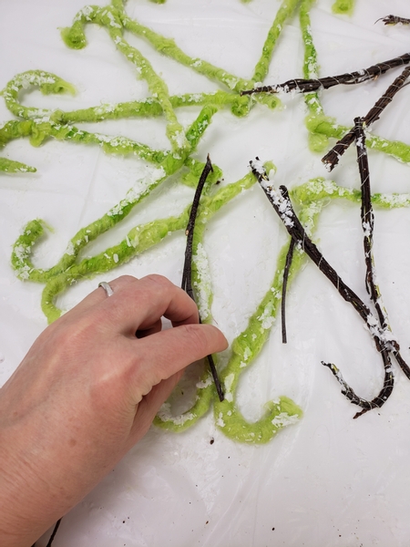 Use hot glue to secure more twigs to the back of the design following the snowflake shape