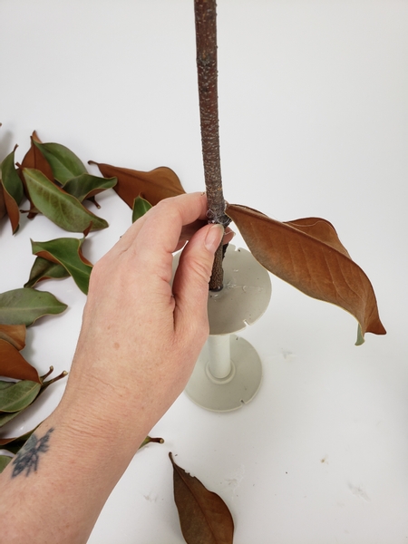 Start at the bottom and glue the leaf to the support twig with hot glue