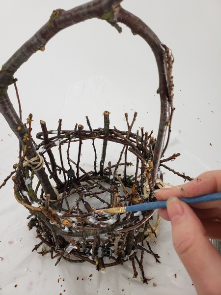 Once all the twigs are in position go over the basket and paint in another layer of glue