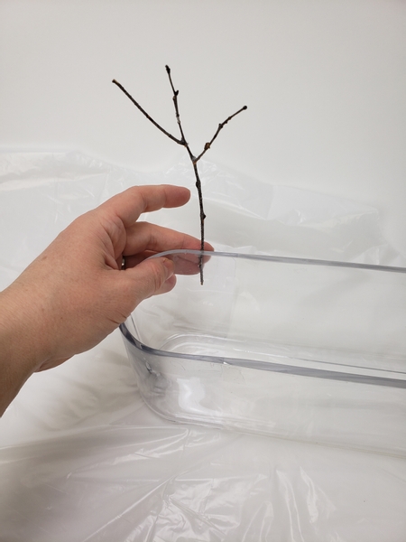 Secure the snowy twigs with hot glue to the exposed sides of the container