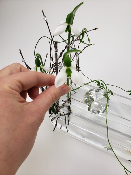 Slip the snow drop flowers into the twig armature