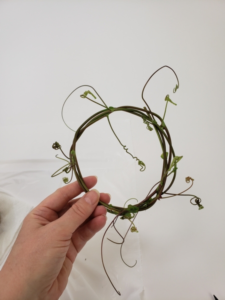 Shape the vine into a wreath that sits snugly around the plastic base of the grass patch