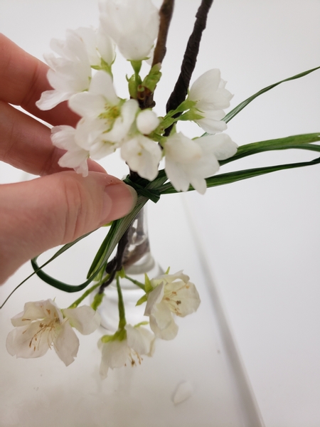 Tie the blossoms into a bunch with a blade of ripped grass Tie the blossoms into a bunch with a blade of ripped grass