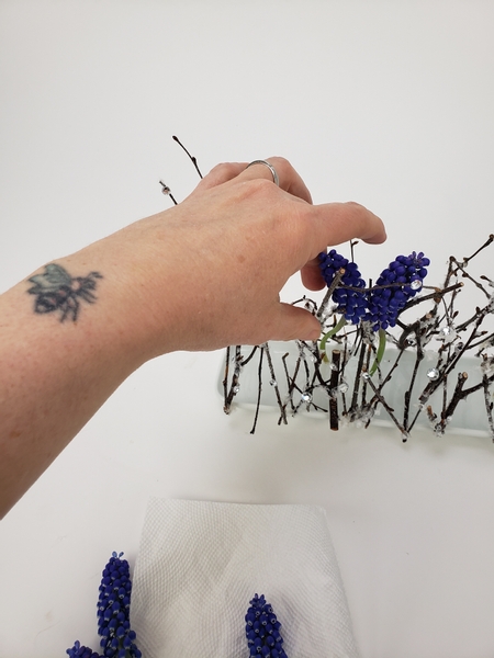 Add in the flowers making sure it stands in the shallow pool of water to remain hydrated Add in the flowers making sure it stands in the shallow pool of water to remain hydrated