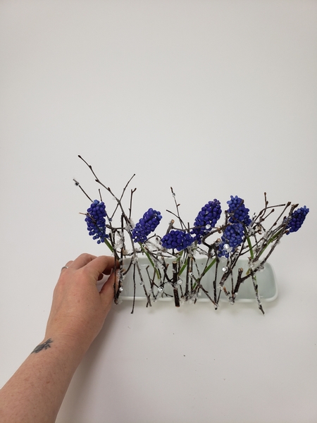 Line up the flowers so that they continue to form the line made by the twig armature