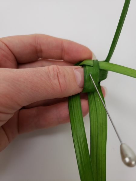 Carefully cut a second slit in the grass with a knife or pin