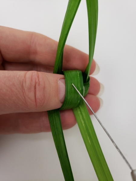 Cut a slit in the grass with a knife or pin