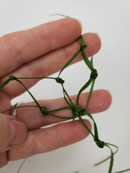 Move all the way around to knot and shape the net pairing the ripped grass with a knot