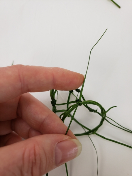 Secure the grass net to the wreath handle with a double knot