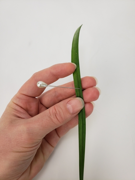 Use a corsage pin to rip grass into sections