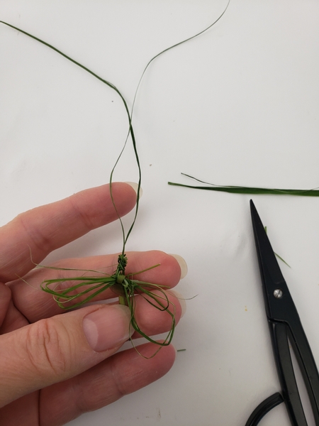 Tie the loose dangling strands into a knot to shape the head