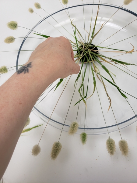 Add grasses to radiate all around the container