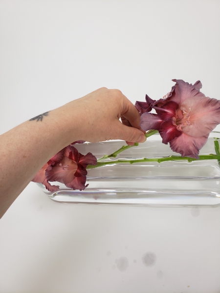 Add in a second gladiolus stem so that the stem fits under the first stem