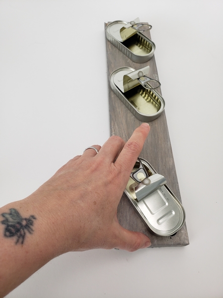 Bend over the lid of an anchovies can and fold the pull tab in into the opening Bend over the lid of an anchovies can and fold the pull tab in into the opening
