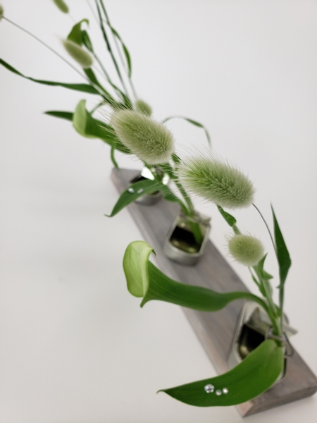 Bunny tail grass and calla lilies in a floral design