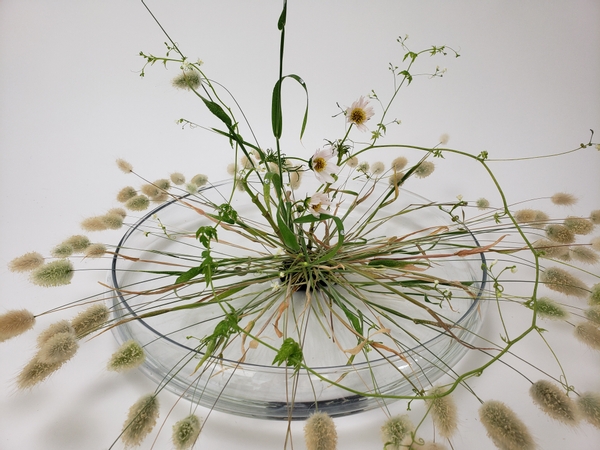 Radiating flower arrangement in water without foam for summer grasses