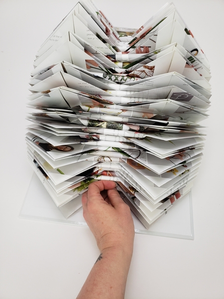 Curl all the middle points in to give you a flat design surface and to neatly fan the book open