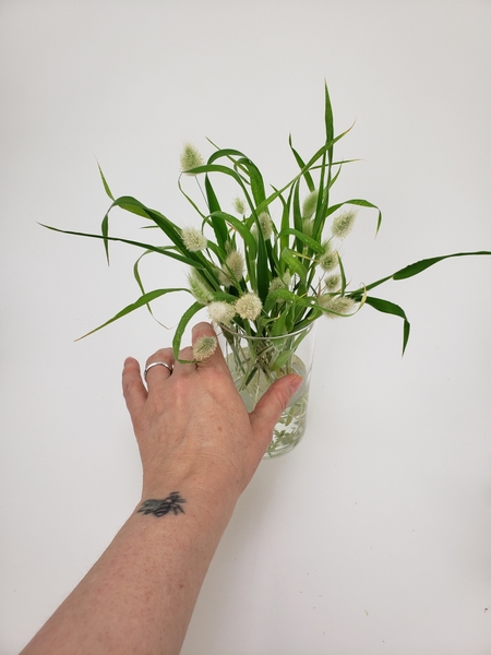 Let the bunny tails settle in the container and arrange them to be pleasing but not over styled