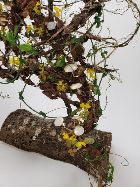 Canary vine flowers and mushrooms in a fall forest floor floral arrangement