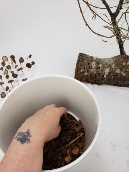 I am using wood chips to cover my armature to craft my mushroom filled forest floor