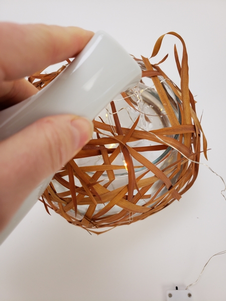 Pour water into the vase through a gap in the grass