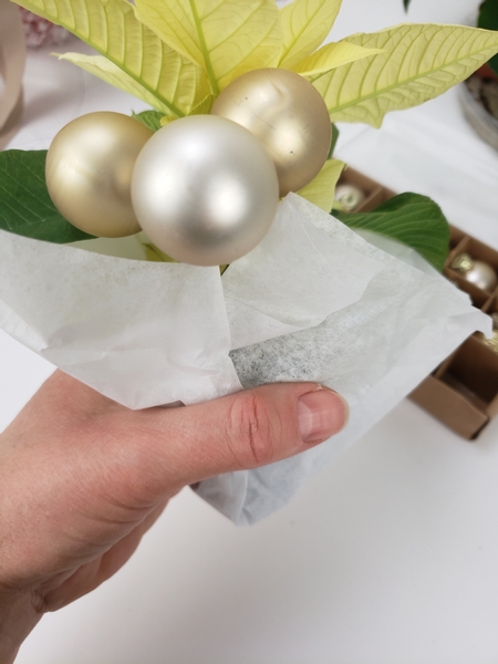 Fold the plastic sheet and the tissue paper up and around the pot