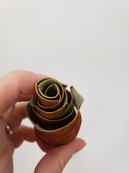 Lift out the next set of curled leaves and glue it just below the first