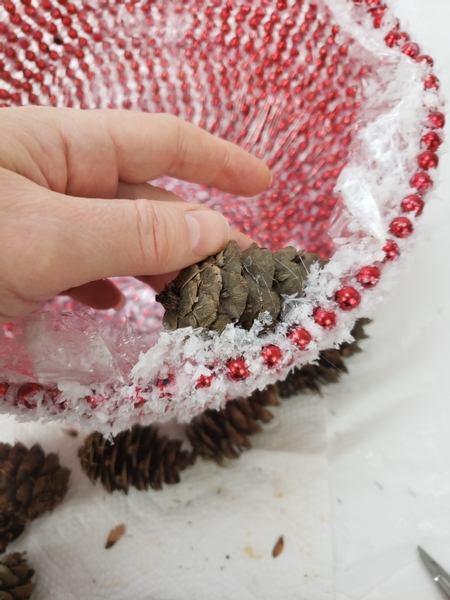 Lift up the snow covered wrap and glue in a seed cone
