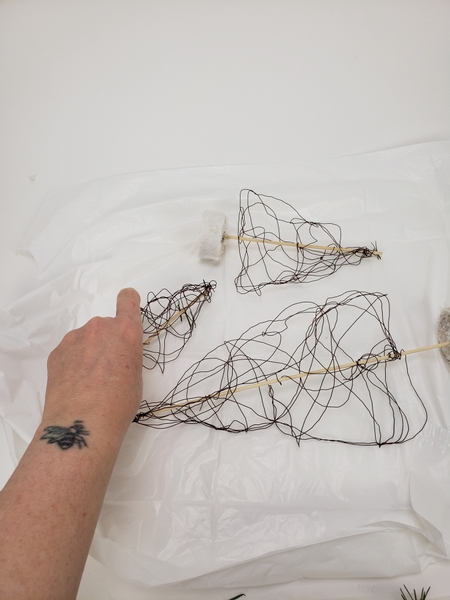 Line your working surface with plastic and place the wire trees on the surface